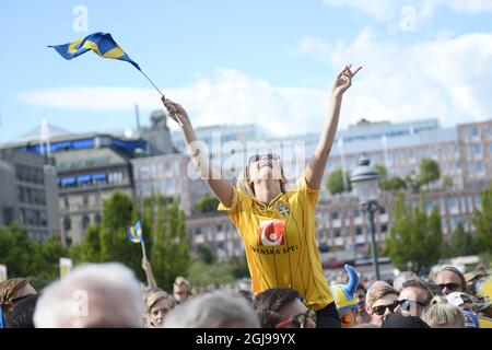 A soccer fan with team jersey and a flag cheers as fans wait for the Swedish U21 national soccer team to arrive in Kungstradgarden in central Stockholm, on July 01, 2015, for the official celebrations the day after their win over Portugal in the Euro U21 soccer championship final match in Prague. Photo: Vilhelm Stokstad / TT / Kod 11370  Stock Photo