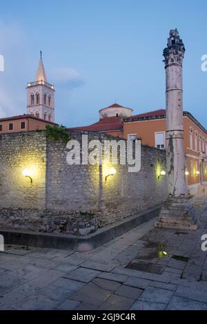 Croatia, Zadar. Roman (49 BC to 5th century) Intact column was used as pillar of shame in medieval times. St. Anastasia and Donatus beyond at twilight Stock Photo