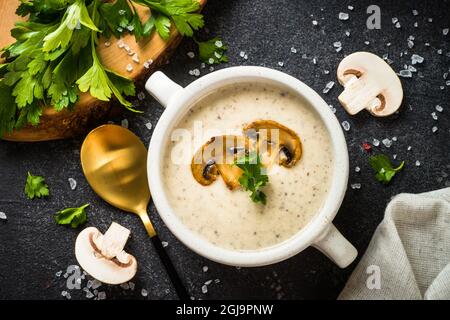 Mushroom Soup in craft bowl on dark stone table. Stock Photo