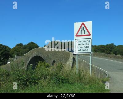 The single-arched, hump-backed Clachan Bridge is known as 'The Bridge over the Atlantic', connecting the Scottish mainland to the Isle of Seil. Stock Photo