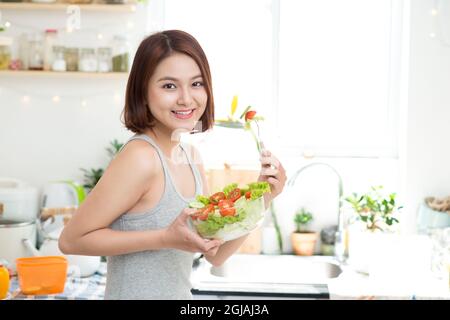Dieting concept. Healthy Food. Beautiful Young Asian Woman eating fresh vegetable salad. Loosing Weight concept Stock Photo