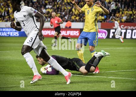 France's goalkeeper Hugo Lloris (C) saves a shot as France's Frankrikes Benjamin Mendy (L) runs away and Sweden's Marcus Berg looks on during the FIFA World Cup 2018 group A qualifying soccer match between Sweden and France on June 9, 2017 at Friends Arena in Solna, Stockholm. Photo Janerik Henriksson / TT / kod 10010  Stock Photo
