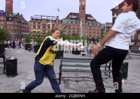 An Arsenal supporter (left) clashes with a Galatasaray supporter in Copenhagen's Town Hall Square before the UEFA Cup final between the two clubs later the same day  Stock Photo