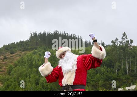 Young male in a Santa Claus suit doing a funny pose outdoors Stock Photo