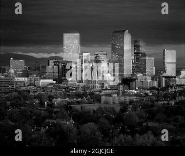 Denver skyline glistens in front of the Rocky Mountains Stock Photo