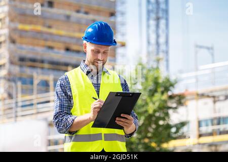 OSHA Inspector At Construction Site. Young Engineer Worker Stock Photo