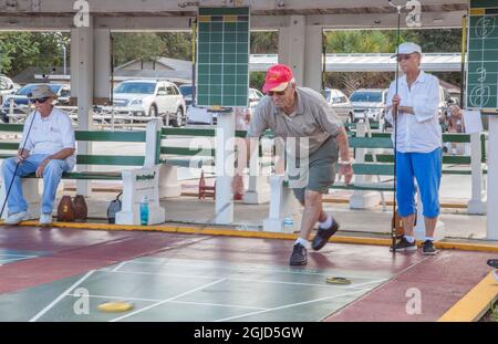 Senior citizens playing competitive shuffleboard game in Flager Ave in New Smyrna Beach, Florida. Stock Photo