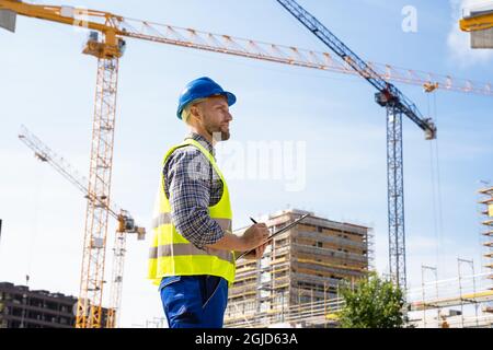 OSHA Inspector At Construction Site. Young Engineer Worker Stock Photo