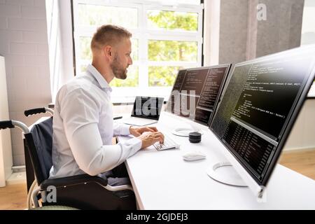 Computer Programmer Writing Program Code On Computer In Office Stock Photo
