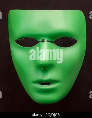 Blank Face Green Half Mask Isolated Against Black Background. Stock Photo