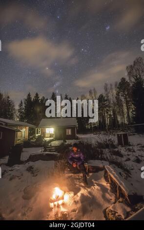 A Man Warms Up By An Open Fire Under A Starry Sky On A Cold And Clear Winter Night Sweden Photo P M Heden Tt Code Stock Photo Alamy