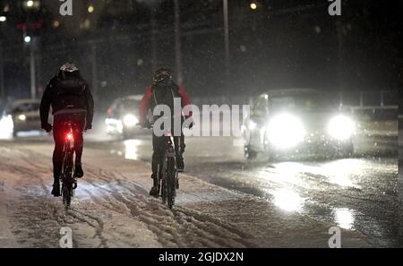 Two people cyling in sleet and rain in Stockholm, Sweden, on January 11, 2021. Photo Janerik Henriksson / TT code 10010  Stock Photo