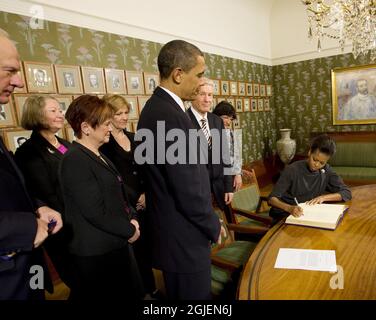 US President Barack Obama looks on as First Lady Michelle Obama signs the guest book at the Nobel Institute in Oslo, Norway Stock Photo