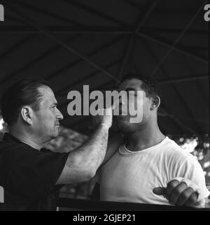 Joe Louis, American boxer, has his rubbed with vaseline by his coach during a training camp in Pompton Lakes, New Jersey. Louis was world heavyweight champion in 1937, he retired as undefeated champion after having defended the title 25 times. Stock Photo