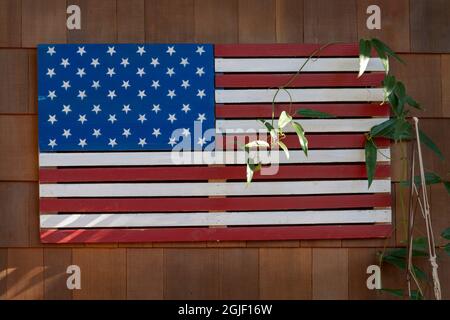 Close-up of American flag made from wood slats on residential cedar shingle wall in Oregon. Stock Photo