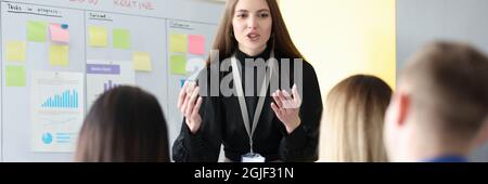 Successful businesswoman standing at blackboard at conference Stock Photo