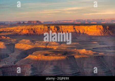 USA, Utah, Glen Canyon National Recreation Area, Sunrise reddens canyons of the San Juan River and distant buttes in Monument Valley; from Muley Point Stock Photo