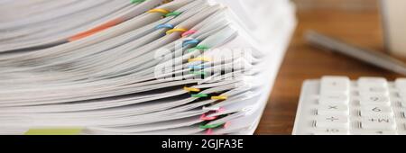 Lot of documents fastened with multicolored paper clips lying on table closeup Stock Photo