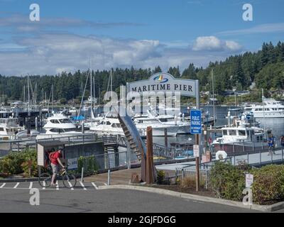 Usa, Washington State, Gig Harbor, man on bicycle near pier. (MR) Stock Photo