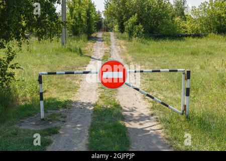 Closed barrier and prohibition sign on a rural road. No entry. Stock Photo