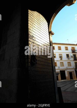 Vertical shot of an open door with an old knocker in Mezquita Cathedral in Cordoba, Spain Stock Photo