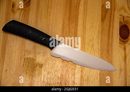 close up old white ceramic knife with a chipped blade. broken substandard knife Stock Photo