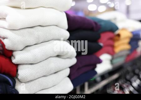 Folded clothes lying on store shelf closeup Stock Photo