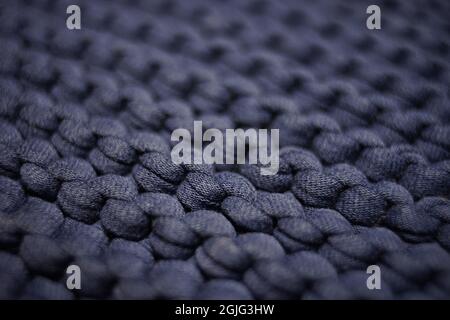 Dark pale blue background large knitted thread pattern. Stock Photo