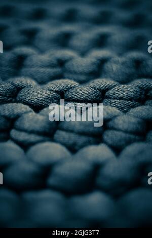 Dark blue grey background massive knitted thread pattern closeup. Stock Photo