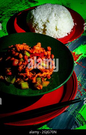 Takeout Chinese kung pao chicken with peanuts and mixed vegetables and white rice Stock Photo