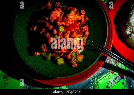 Takeout Chinese kung pao chicken with peanuts and mixed vegetables and white rice Stock Photo