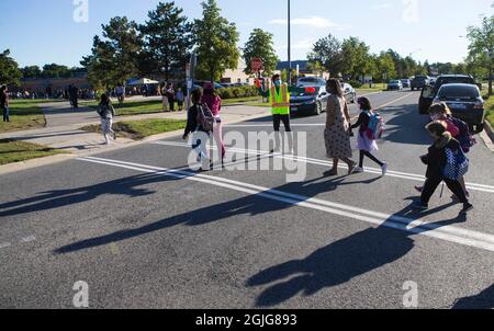 Mississauga, Canada. 9th Sep, 2021. A crossing guard wearing a face mask works on a street outside a school in Mississauga, the Greater Toronto Area, Ontario, Canada, on Sept. 9, 2021. Schools in Toronto, Peel, York and Durham started their school years on Thursday, offering a mix of in-person classes and online learning for students. Credit: Zou Zheng/Xinhua/Alamy Live News Stock Photo
