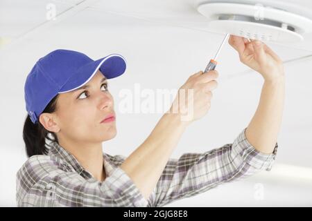 female worker screwing something in the ceiling Stock Photo - Alamy