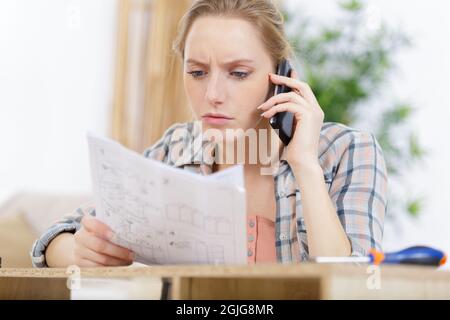 woman on the phone checking design plans Stock Photo