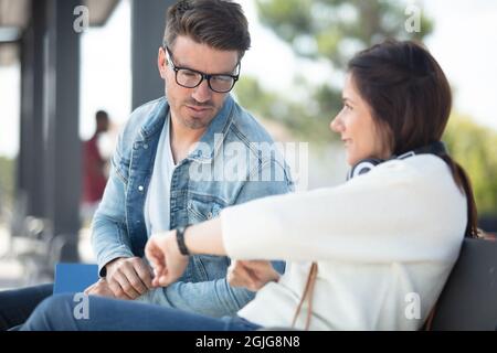 couple waiting on train station looking at watch Stock Photo