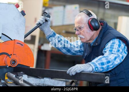 senior man operating machine in the factory Stock Photo
