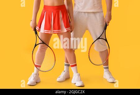 Cheerleader and tennis player on color background Stock Photo