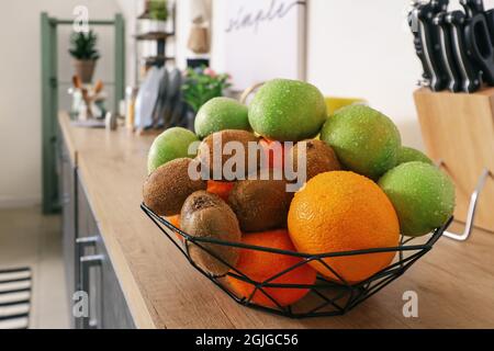 Basket with fresh fruits on counter in kitchen, closeup Stock Photo