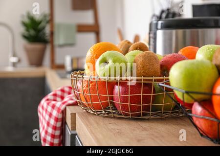 Basket with fresh fruits on counter in kitchen, closeup Stock Photo