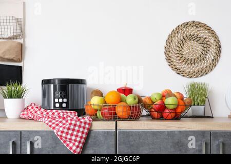 Baskets with fresh fruits on counter in kitchen Stock Photo