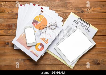 Stack of documents, smartphone and tablet computer on wooden table Stock Photo