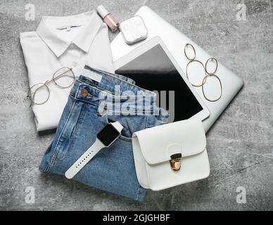 Female clothes, stylish accessories and modern gadgets on grey background Stock Photo