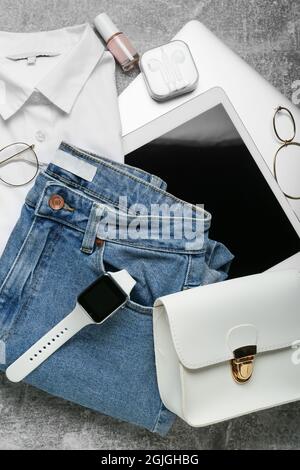 Female clothes, stylish accessories and modern gadgets on grey background Stock Photo