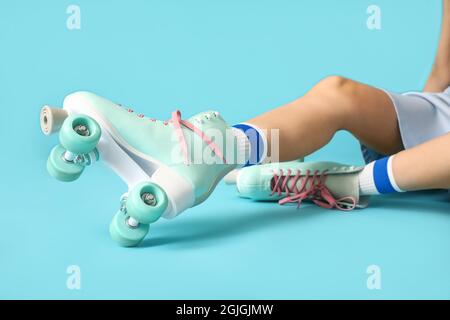 Young woman in roller skates on color background Stock Photo