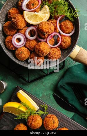 Frying pan with tasty cod cutlets on color background Stock Photo