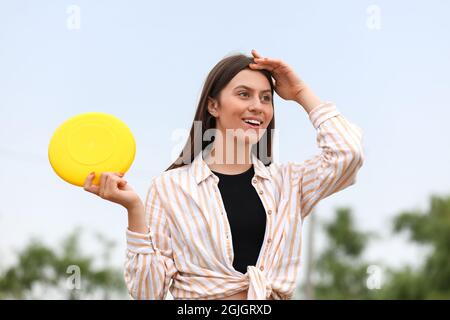 Beautiful young woman playing frisbee outdoors Stock Photo