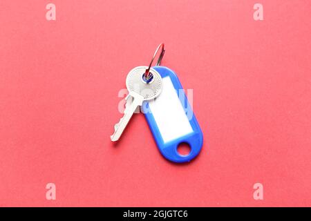Plastic tag with key on color background Stock Photo