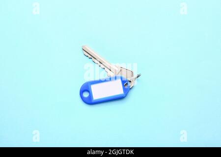 Plastic tag with key on color background Stock Photo