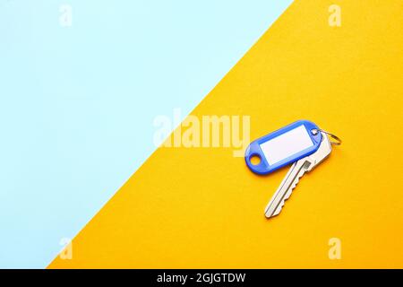Plastic tag with key on color background Stock Photo