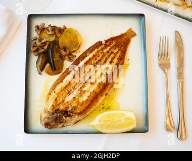 Fried sole fish with baked vegetables and lemon Stock Photo